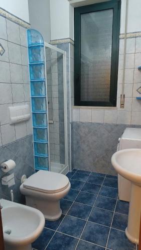 a bathroom with a toilet and a sink and a shower at CRema Beach in Palmi