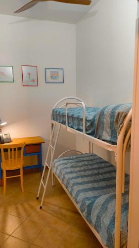 a bedroom with two bunk beds and a desk at CRema Beach in Palmi