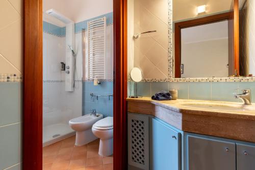 a bathroom with a sink and a toilet and a mirror at Flamingo Poetto in Quartu SantʼElena