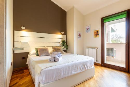 a bedroom with a large white bed and a window at Flamingo Poetto in Quartu SantʼElena