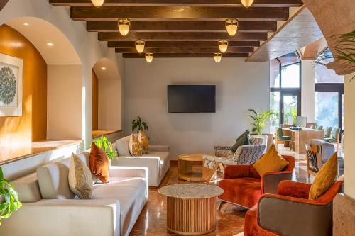 a living room with couches and a tv at Villa Del Palmar Flamingos Beach Resort & Spa in Nuevo Vallarta