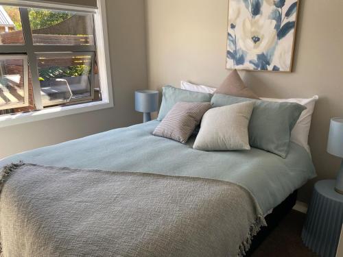 a bedroom with a bed with pillows and a window at Sunny Clyde Getaway in the Heart of Clyde in Clyde