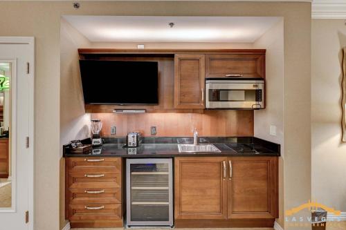 a kitchen with wooden cabinets and a sink and a microwave at MGM Signature 03-818 Jacuzzi Studio in Las Vegas