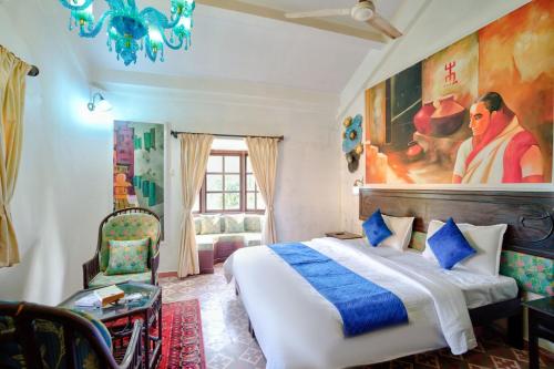 a bedroom with a bed and a painting on the wall at Baagh House villa Velsao in Cansaulim