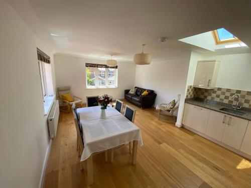 a kitchen and dining room with a table and a kitchen and a living room at Lovely Central Romsey Apartment in Romsey