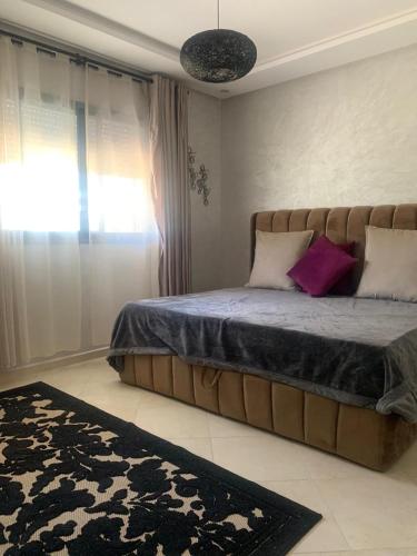a bedroom with a large bed with purple pillows at Sable d or Mansoria in Aïn Harrouda