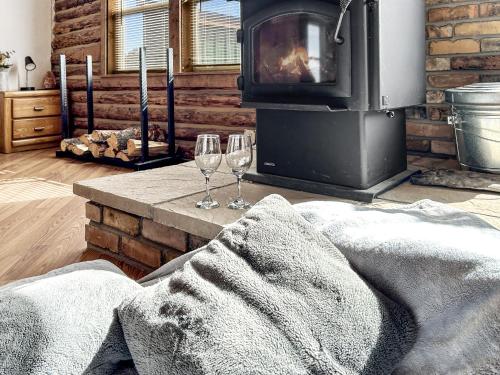 a living room with two wine glasses and a fireplace at Cedar Mountain Bunkhouse cabin in Montrose