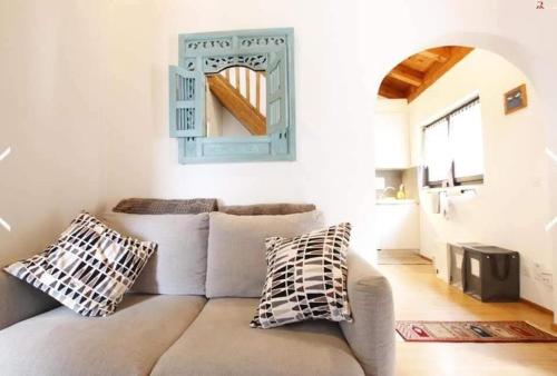 a living room with a couch and a mirror at LA COLLINETTA appartamento di vacanza in Collina d'Oro