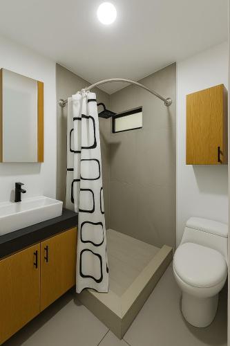 a bathroom with a toilet and a shower curtain at Modern apartment with pool , Riviera Nayarit in Naranjo