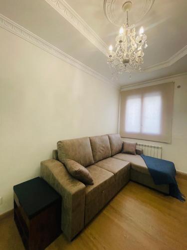 a living room with a couch and a chandelier at Apartamento Oyón in Logroño