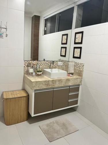 a bathroom with a sink and a mirror at Apto Moderno no Centro - Completo e Confortável in Americana