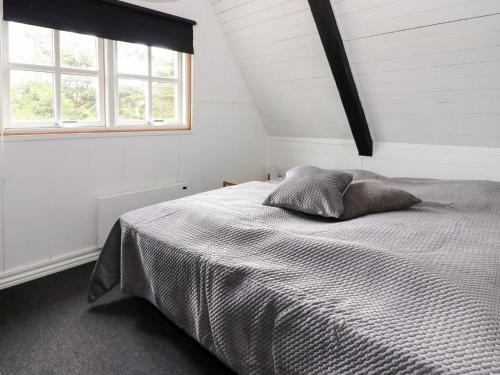 a white bedroom with a bed with two pillows at Tranquil Waterfront Cottage-By Traum in Hadsund