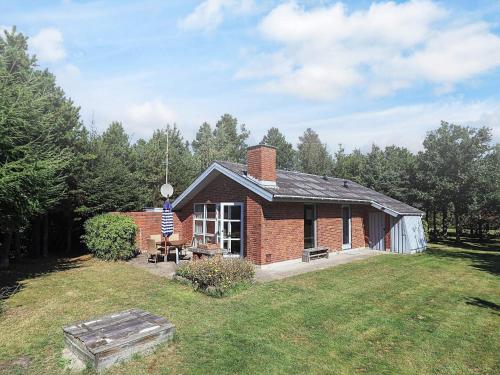 a small brick house with a flag on it at Cozy Retreat near Marielyst - By Traum Ferienwohnungen in Bøtø By