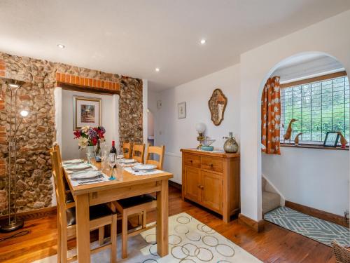 a dining room with a wooden table with chairs and a tableablish at Little Crawfish Cottage in Thursford