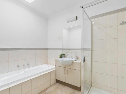 a bathroom with a tub and a sink and a shower at Elsinor 4 in Mulwala