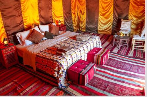 a bedroom with a bed in a tent at Erg Chegaga Camp Excursions Stéphanie in Mhamid