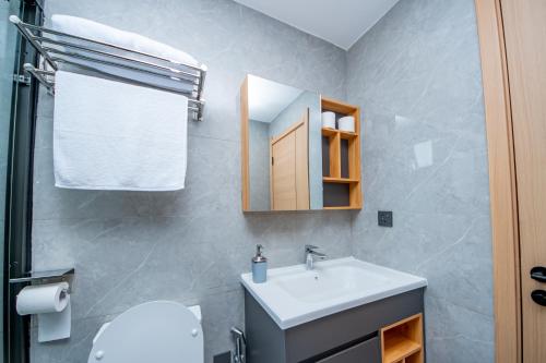 a bathroom with a sink and a toilet and a mirror at The Residence -Juction Mall in Nairobi
