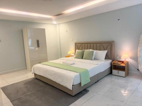 a bedroom with a large bed and two night stands at Spacious 5BR Townhouse in Central Phnom Penh in Phnom Penh
