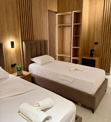 a hotel room with two beds with white sheets at Karos Hotel Llaman in Himare