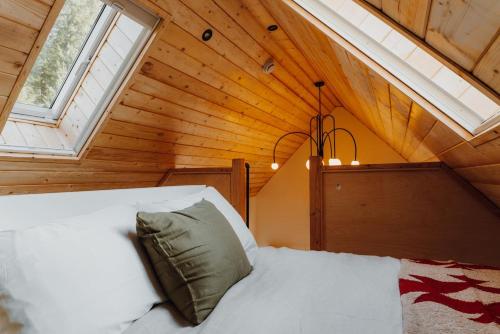 a bedroom with a white bed in a attic at Camp Alta in Packwood