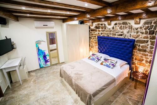 a bedroom with a blue bed in a brick wall at Apartment Genius Loci in Split