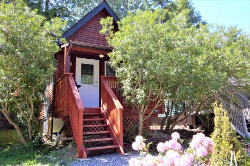 a tiny house with a staircase leading to a door at Cozy Cabin Near Walking Trails And Beaches! in Ucluelet