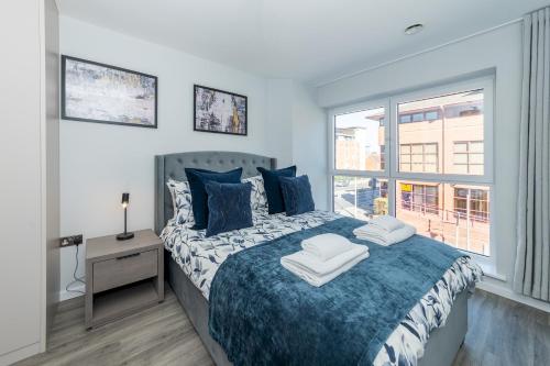 a bedroom with a large bed with a window at Brand New Flat with AC 5-Min Walk to Town Centre - Pass the Keys in Reading
