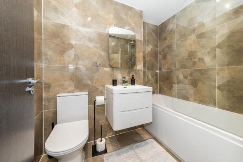a bathroom with a toilet and a sink at Brand New Flat with AC 5-Min Walk to Town Centre - Pass the Keys in Reading
