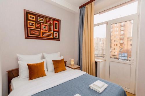 una camera da letto con un letto e una grande finestra di Cascade View Apartment a Yerevan