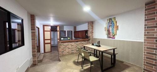 a room with a table and chairs and a brick wall at Aloja-T Hostal Jericó in Jericó