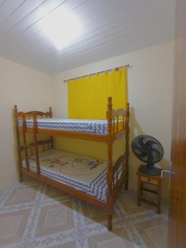 a bedroom with a wooden bunk bed with a yellow curtain at Sítio de Vavá in Gravatá