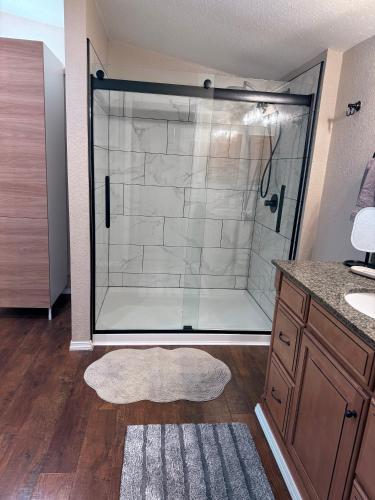 a bathroom with a shower with a glass door at Sugar Maple Getaway in Gaylord