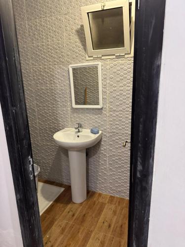 a bathroom with a sink and a tv on the wall at Le Nide d'azrou in Azrou