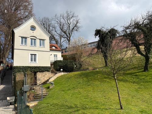 a white house on top of a grassy hill at Gabi`s Villa am Hang in Bad Aibling