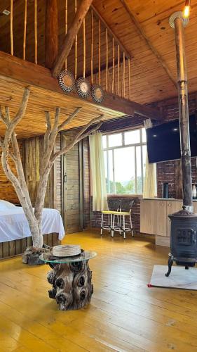 a room with a tree and a stove in it at Studio Rústico - Refúgio Arara Azul in Urubici