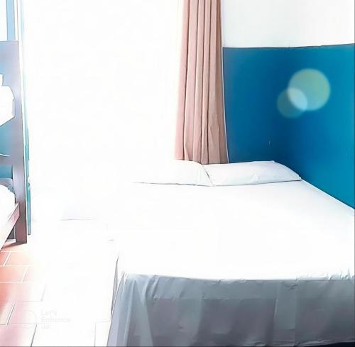 a bed in a room with a large window at Hotel e Pousada das Goianas in Santos