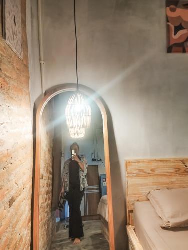a woman taking a picture of herself in a mirror at Loti Guest House in Kupang