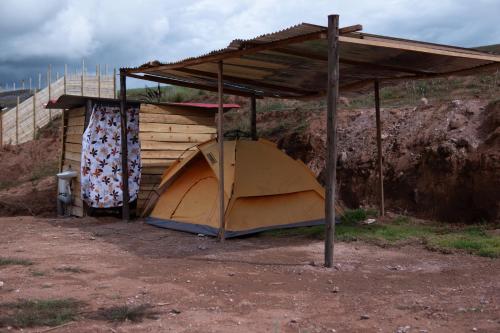 a tent under a roof on top of a hill at Camping tres nevados in Urubamba