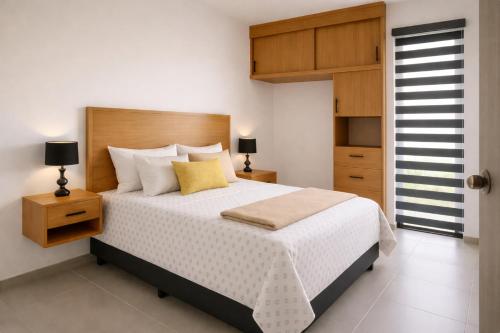 a bedroom with a large bed with a wooden headboard at Modern apartment with pool , Riviera Nayarit in Naranjo