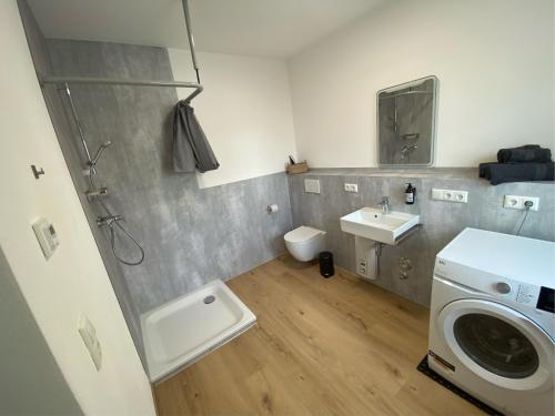 a bathroom with a washing machine and a sink at kreuzwirt bayern in Essenbach