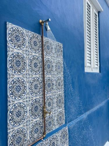 a blue building with a blue wall with a window at Dushi Blou, private monumentje in Otrabanda in Willemstad