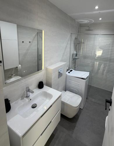 a white bathroom with a sink and a toilet at Apartment A&T La Mata in La Mata