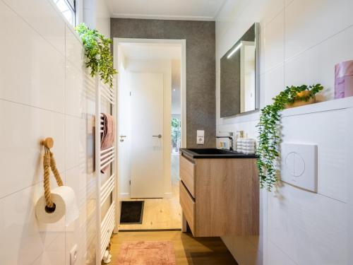 a bathroom with a sink and a mirror and a door at Het Hertenpad in Hattemerbroek