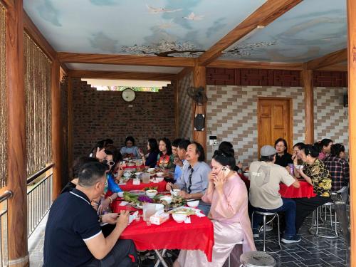 a group of people sitting at a table eating at Trần Sơn Homestay in Tuyên Quang