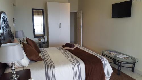 a bedroom with a bed and a lamp and a table at The Homestead Margate - South Africa in Margate