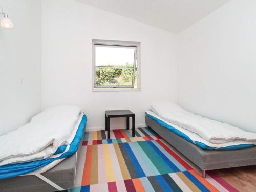 two beds in a room with a window at 8 person holiday home in Melby in Melby