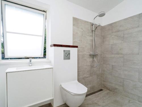 a white bathroom with a toilet and a shower at 8 person holiday home in Melby in Melby