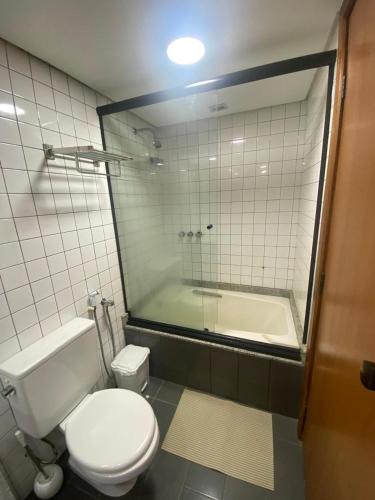 a bathroom with a toilet and a bath tub at Vitória Marina Flats in Salvador