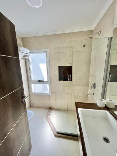 a bathroom with a tub and a sink and a window at Monoambiente PIPE in Bella Vista