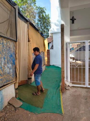 a man standing on a green carpet in a house at Cookiewalla in Arambol